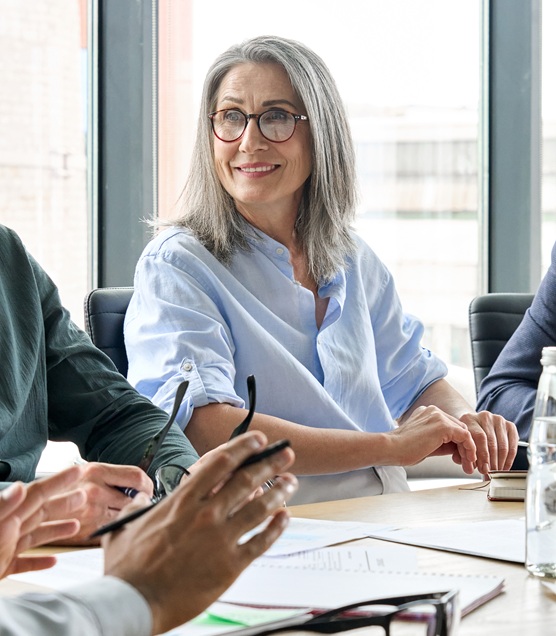 smiling female ceo looking at male manager colleague at table meeting.