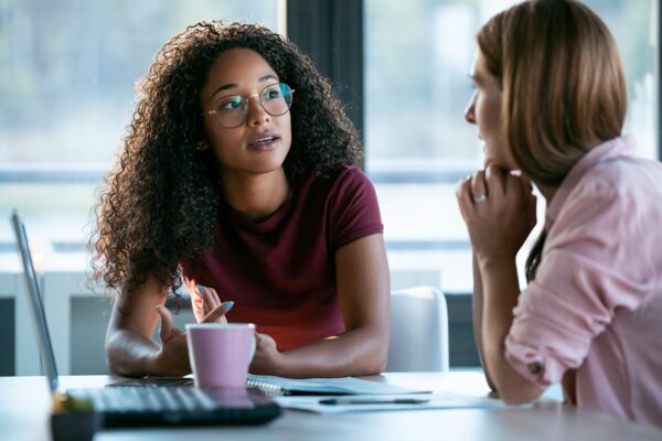 two beauty business women working together with laptop while tal