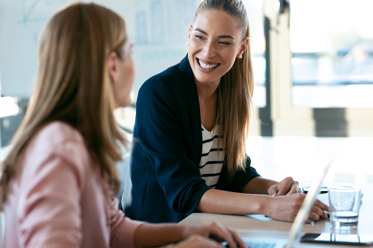 two beauty business women working together with laptop while tal