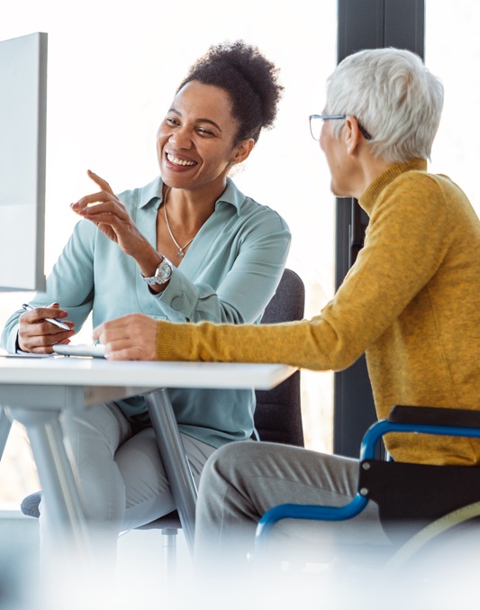 mentorship and diversity in a modern office as colleagues share a laptop for team collaboration